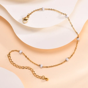 Détail de la chevillère dorée avec perles en marbre blanc et fermoir mousqueton