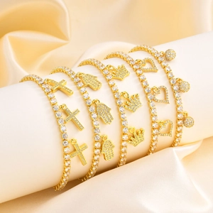 Gold tennis bracelets with Hamsa Hand, cross, crown, heart, and ball charms for women