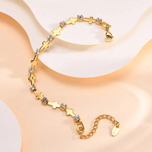 Détail d'un bracelet en or 18 carats avec breloques croix et zircons étincelants