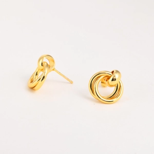 Detail of twisted multi-loop golden stud earrings with a polished metallic finish