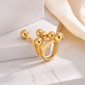 Bague boules dorées sur pierre de marbre blanc avec fond en tissu de soie crème luxueux