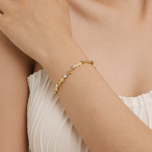 Bracelet en acier inoxydable plaqué or 18 carats avec croix et zircons sur poignet