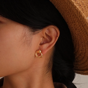 Fashionable gold interlocking double ring twisted hoop earrings for women, model wear view