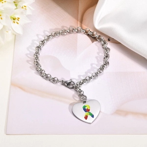 Dettaglio del ciondolo a cuore in acciaio inossidabile con simbolo puzzle autismo sulla catena