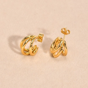 Close-up of golden triple-strand C-shape earrings with polished finish and butterfly backs