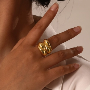 Macro shot of chunky gold stainless steel triple-layered spiral ring on finger