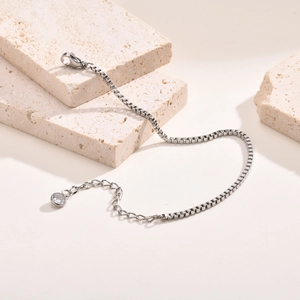 Détail d'un bracelet maille vénitienne argenté avec fermoir mousqueton et zircon rond