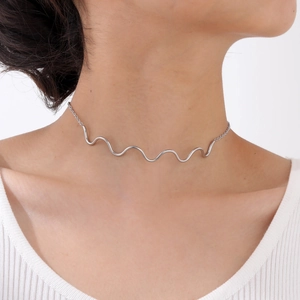 Close-up of a silver polished wave choker necklace on a female model neck