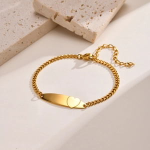 Minimalist gold stainless steel heart bar bracelet with Cuban chain on stone background