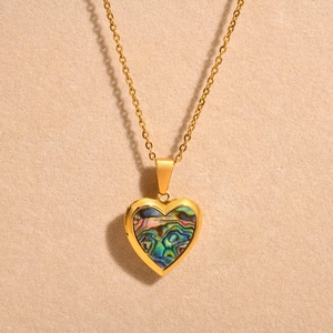 Detailed view of golden heart locket necklace with colorful abalone shell inlay