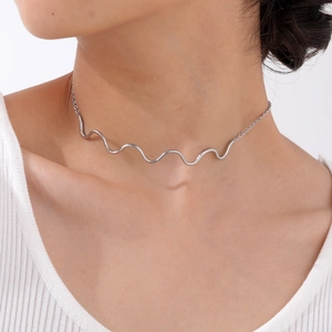 Detailed view of silver wave choker necklace on model featuring polished mirror finish