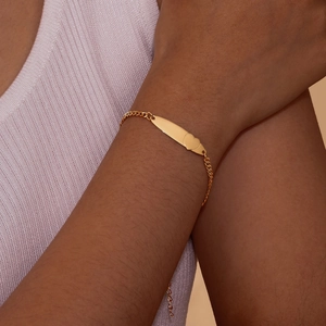 Elegant gold-tone stainless steel heart and bar bracelet on female wrist with sweater