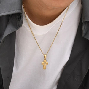 Golden baroque cross pendant necklace with engraved texture shown on a male model