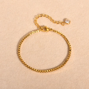 Détail du bracelet chaîne vénitienne dorée avec fermoir mousqueton et pendentif en zircon