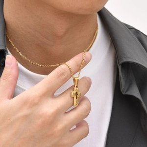 Close-up of gold-plated stainless steel cross necklace worn by model for hip hop style