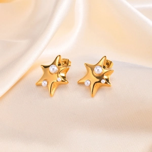 Boucles d'oreilles étoiles en acier inoxydable doré avec perles sur fond de soie beige