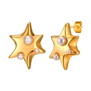 Boucles d'oreilles étoiles en acier doré avec perles blanches sur fond blanc