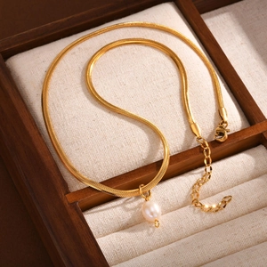 Detail einer goldenen Schlangenkette mit runder Perle und verstellbarem Verschluss