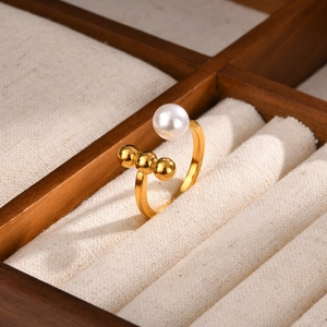 Detail of gold-plated stainless steel open ring with a pearl and three small gold beads