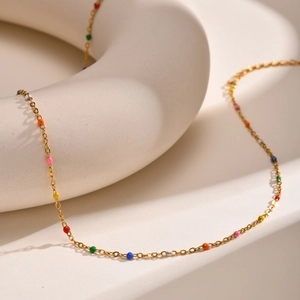 Bohemian gold stainless steel necklace with multi-colored enamel beads on a display ring