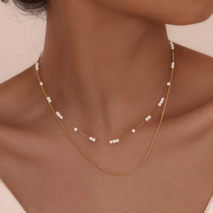 Elegant gold double layer necklace featuring round pearl bead chain and smooth snake chain