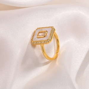 Macro shot of gold octagonal ring featuring white shell inlay and zircon halo setting