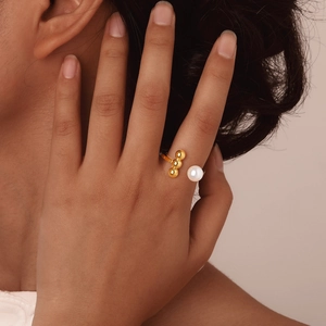 Golden stainless steel open ring featuring a white pearl and three metallic beads on finger
