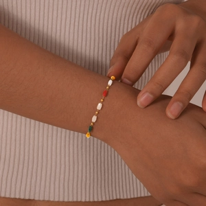 Detail of 18K gold stainless steel chain bracelet with colorful rectangular beads on wrist