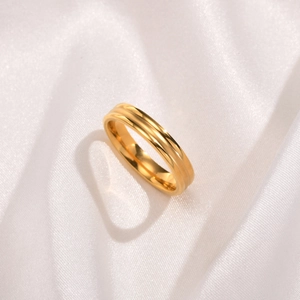 Detailed view of a three-layered gold stainless steel ring on white satin fabric