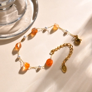 Detailed macro of gold-plated chain bracelet with amber-style beads and K18 hallmark tag