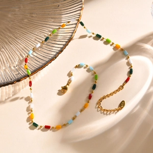 Macro shot of 18K gold chain with colorful beads and K18 hallmark on the clasp tag
