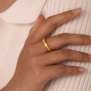 Elegant woman wearing a triple-layered gold stainless steel ring with a white knit sweater