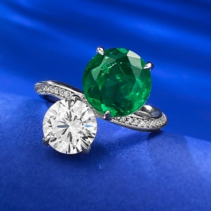 Macro shot of 10mm emerald and diamond ring with pave setting on a blue wave background