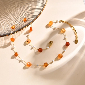 Detail of beaded bracelet with amber stones, pearls, and K18 engraved gold metal tag