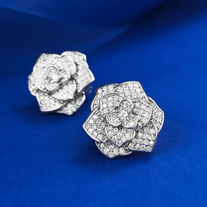 Exquisite S925 silver camellia stud earrings with full pave cubic zirconia on blue silk
