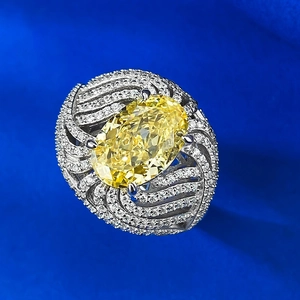 Dettaglio macro dell'anello con diamante giallo ovale e montatura a onde con pavé