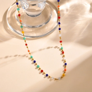 Detail of colorful square beads on a gold chain with elegant water caustic reflections
