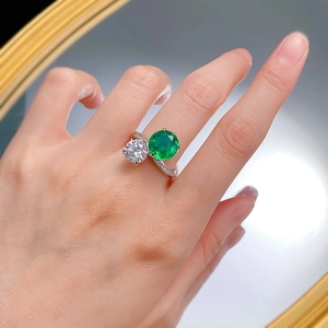 Close-up of S925 silver bypass ring with 10mm emerald green and white round gemstones
