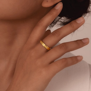 Minimalist gold three-layer stainless steel ring for women shown on a model's finger