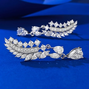 Elegante S925 Silber Feder Ohrringe mit Eiskristall Schliff Diamant in Blauem Hintergrund