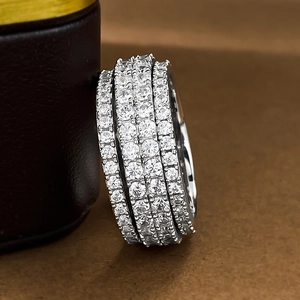 Macro detail of a wide silver band ring featuring four rows of pave-set round-cut zircons