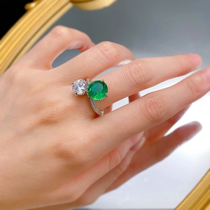Detail of S925 silver Toi et Moi ring with emerald green stone and white round zircon