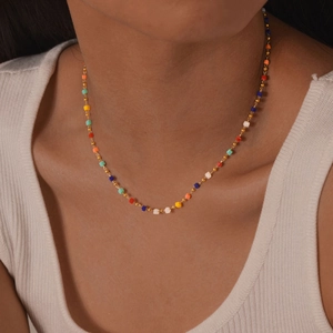 Close-up of gold stainless steel chain necklace with colorful square beads on a model