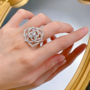 Macro shot of S925 silver camellia flower ring with pavé-set sparkling zircons on finger