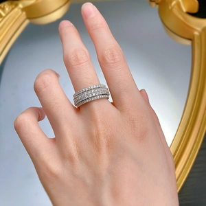 Close-up of wide multi-layer silver ring with pave-set diamonds on finger