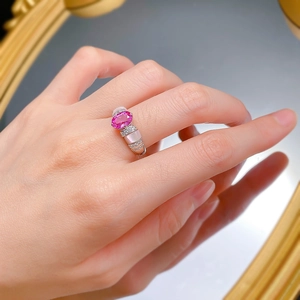 Détail d'une bague en argent 925 avec rubis rose et incrustations de nacre sur le doigt