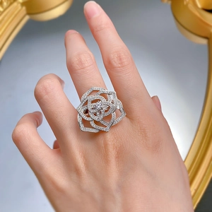 Detailed close-up of a S925 silver camellia ring with sparkling crystals on a hand