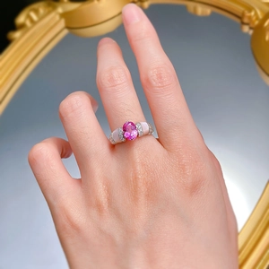 Détail d'une bague en argent 925 avec coquillage rose et pierres rubis sur la main
