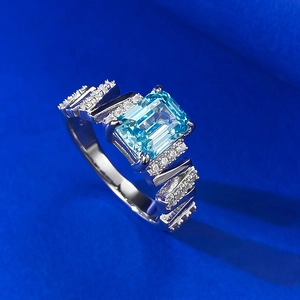 Macro shot of rectangular aquamarine ring with geometric silver band and small diamonds