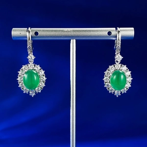 Macro view of 925 silver stud earrings with oval green chalcedony and zircon halo